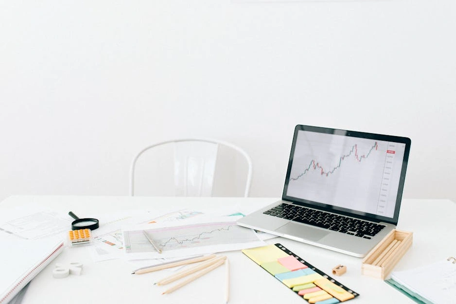 Eine moderne Handelsoberfläche auf einem Laptop-Bildschirm mit Börsencharts im Hintergrund.